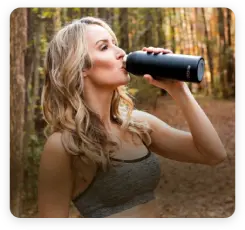 lady drinks from UVBrite in the woods